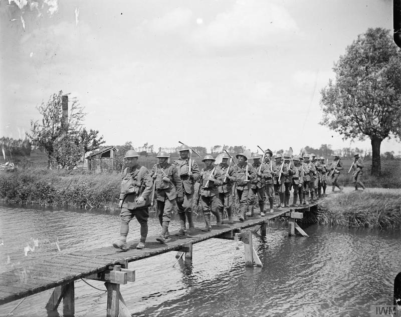 A working party of the Duke of Wellington's Regiment (West Riding) returning, crossing the canal by a footbridge. Between Carvin and Robecq, 18 June 1918. Imperial War Museum image Q6711
